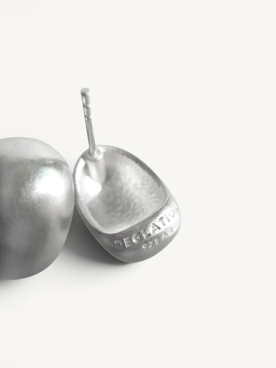 Back view of handcrafted rhodium-plated sterling silver oval stud earrings showcasing secure post backs and quality artisan finishing.