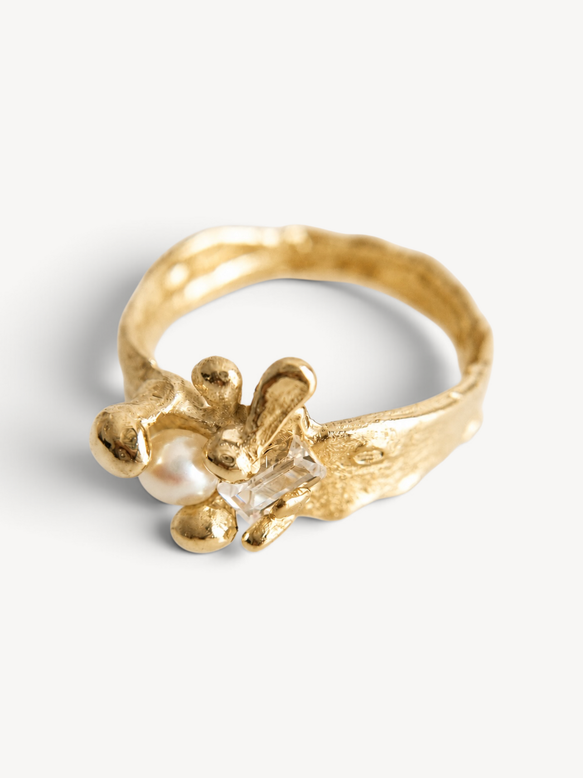 Top view of a handcrafted 14k gold-plated sterling silver statement ring with a freshwater pearl and rectangular-cut white zircon.