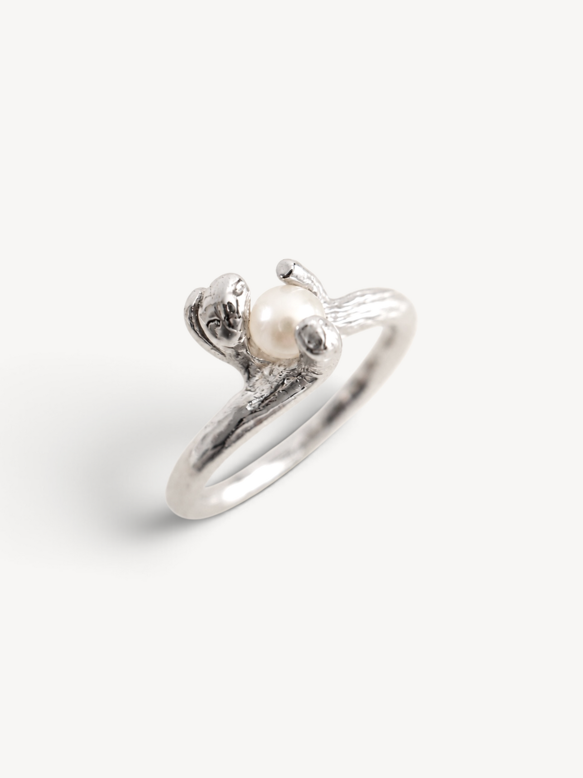 Side view of a handcrafted rhodium-plated sterling silver pearl ring with an organic contemporary design.