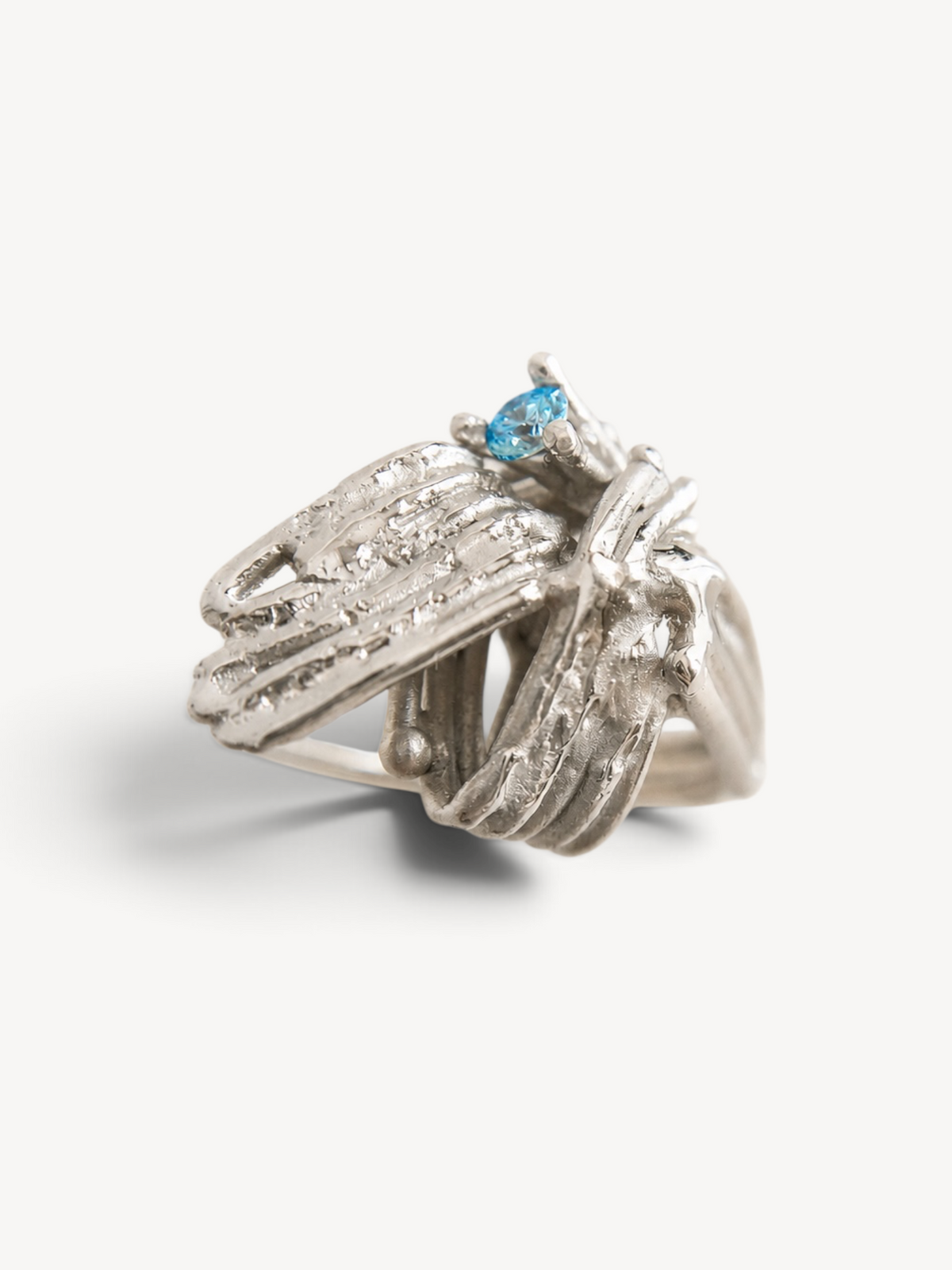 Handmade sculptural rhodium plated sterling silver ring with navy blue zircon stones.