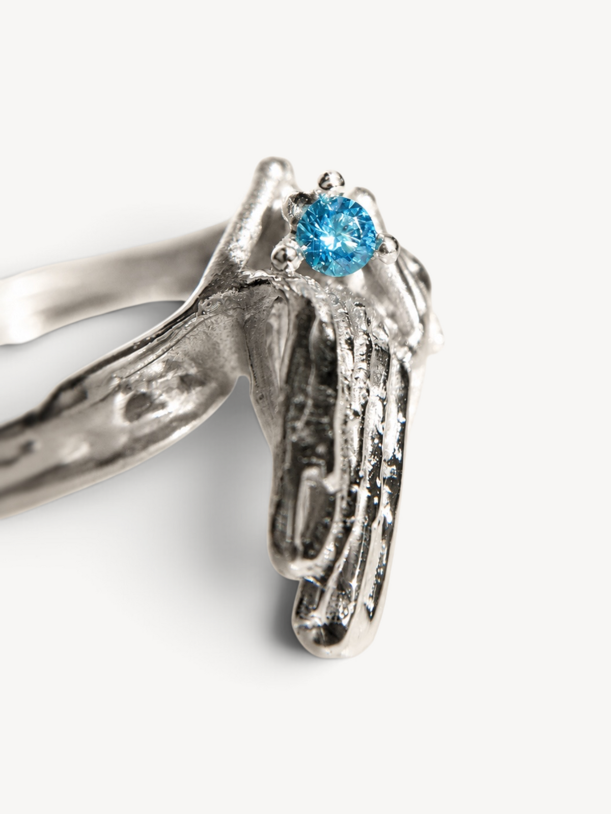 Close-up of the textured rhodium plated sterling silver surface and navy blue zircon stone.
