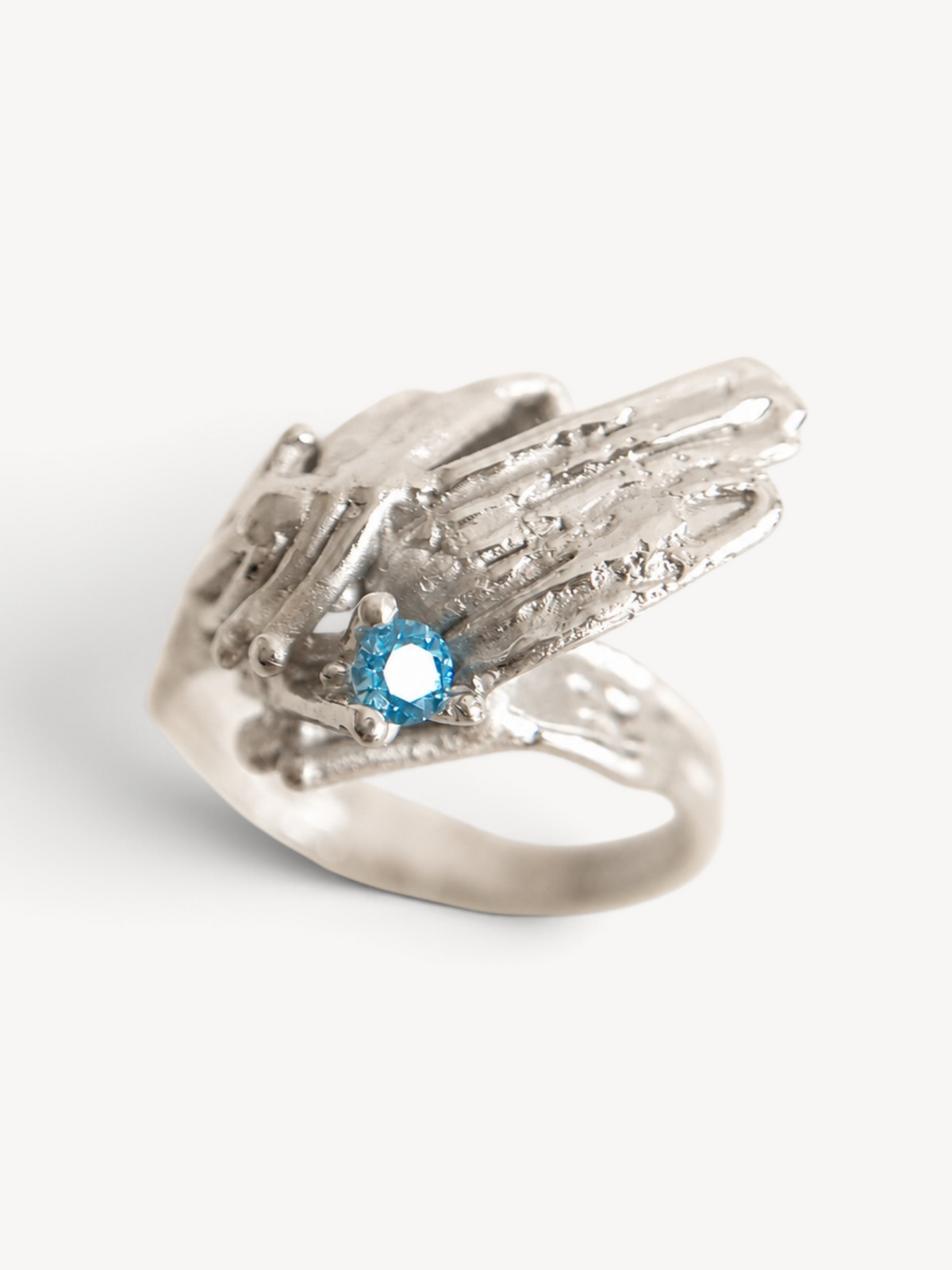 Top view of the sculptural rhodium plated sterling silver ring with navy blue zircon stone