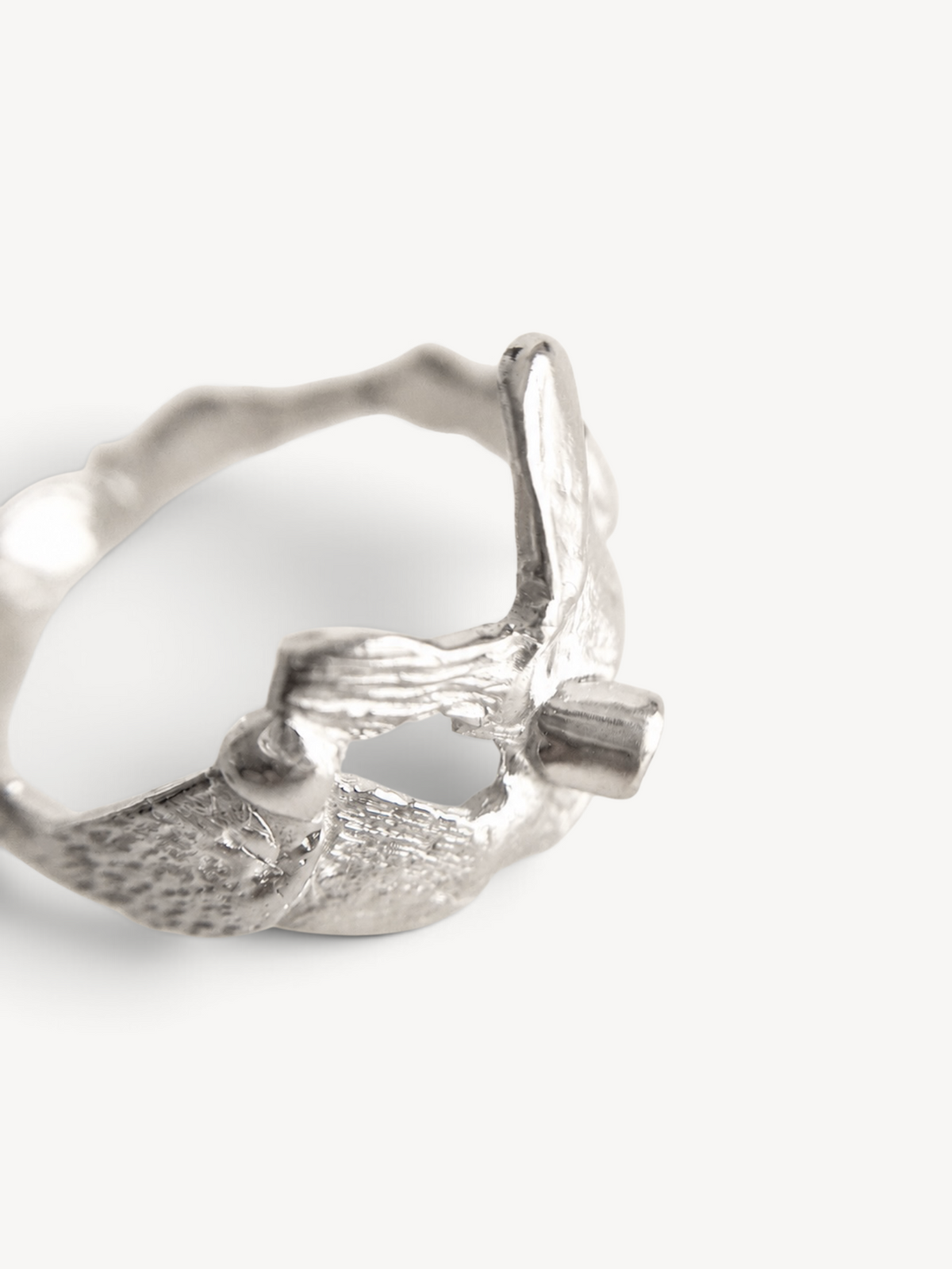 Rear angle of a handcrafted rhodium-plated sterling silver ring showcasing its sculptural floral-inspired form and handcrafted texture.