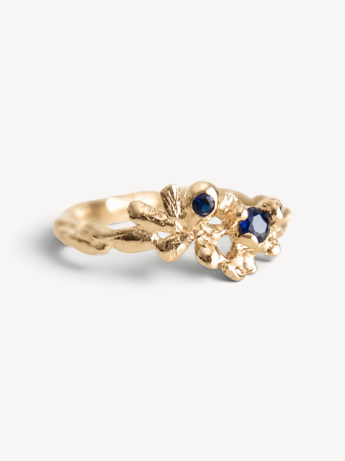 Close-up of the textured 1.0 micron 14k gold plated sterling silver surface and indigo zircon stones.
